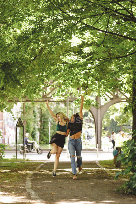 Mulheres alegres andando na rua verde de verão em Berlim no dia ensolarado — Fotografia de Stock