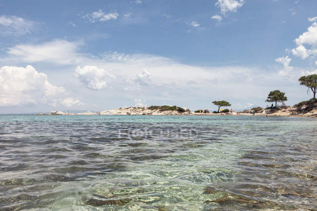 Pittoresca vista dell'isola rocciosa e del fondo del mare nella soleggiata giornata estiva a Halkidiki, Grecia — Foto stock