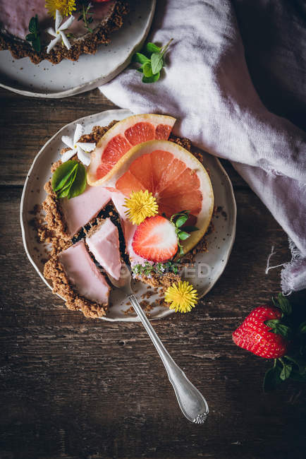 Blick von oben auf köstliche Erdbeer- und Zitruskuchen auf dekoriertem Holztisch — Stockfoto