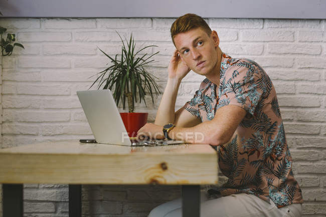 Homme concentré assis avec ordinateur portable à la table dans un café — Photo de stock