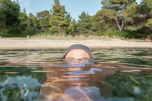 Fronte dell'uomo nuotatore completamente sommerso dall'acqua nella giornata di sole, Halkidiki, Grecia — Foto stock