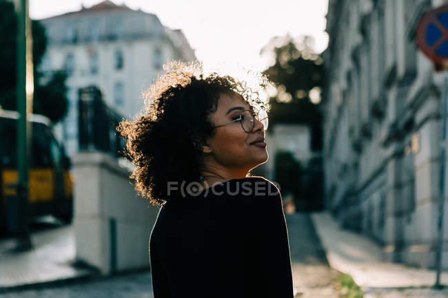 Дивна афро-американська жінка на чорному даху стоїть на тротуарі і дивиться на камеру — стокове фото