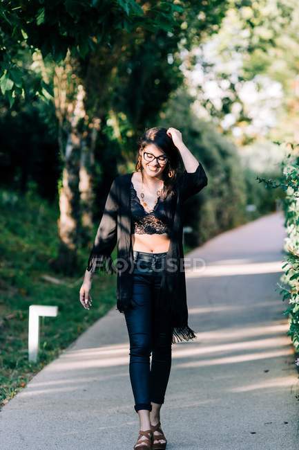 Trendy young woman walking along paved path and enjoying summer day in Lisbon — Stock Photo
