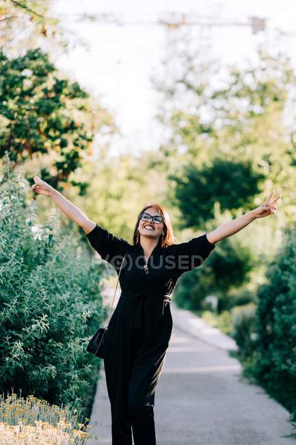 Trendy young woman walking along paved path and enjoying summer day in Lisbon — Stock Photo