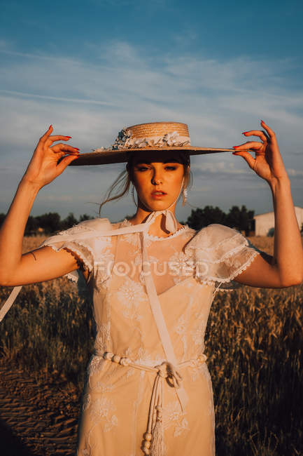 Mulher em chapéu redondo grande no meio do campo de trigo — Fotografia de Stock