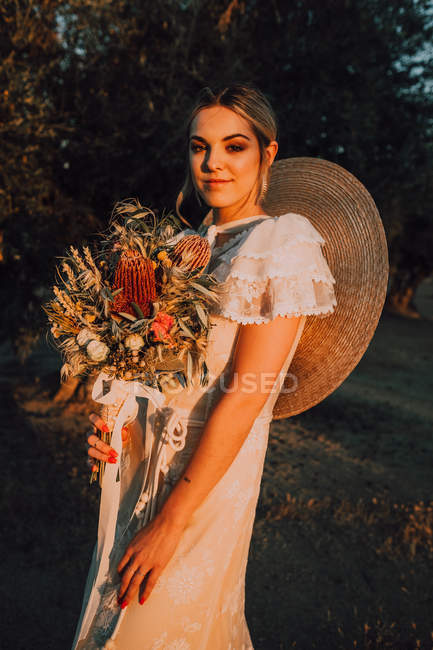 Mulher de vestido com buquê de flores — Fotografia de Stock