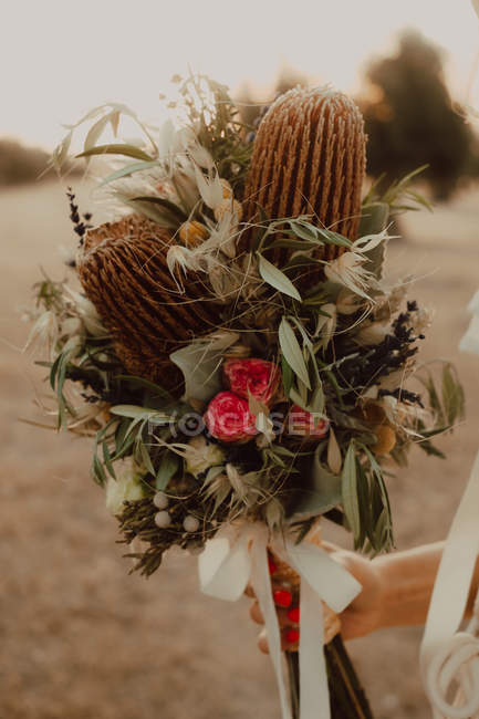 Cropped image of Woman in dress with flower bouquet — Stock Photo