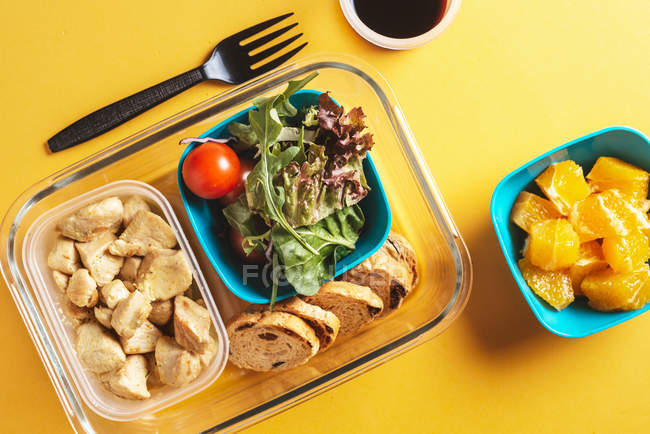 Recipientes de plástico com alimentos saudáveis e garfo preto — Fotografia de Stock