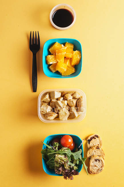 Contenedores plásticos con alimentos saludables y tenedor negro - foto de stock