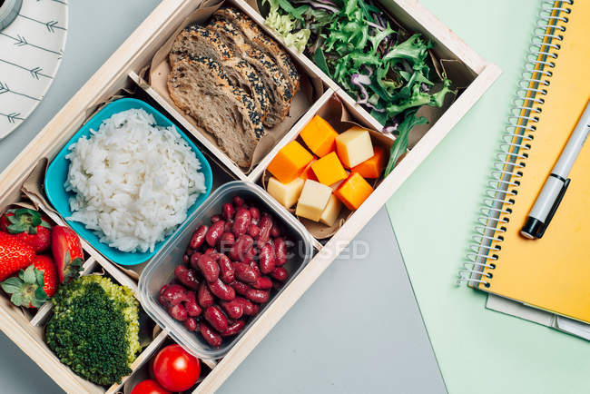 Scatola degli alimenti con ingredienti dietetici per copybook e piatto — Foto stock
