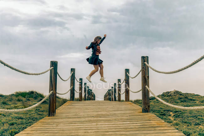 Bella giovane femmina saltando in aria sopra la passerella a gravità zero — Foto stock