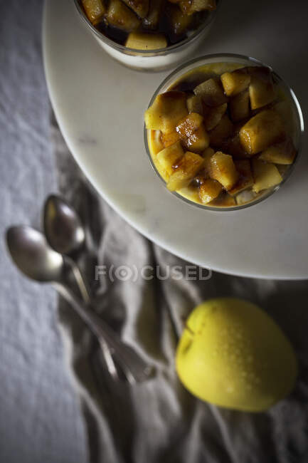 Da suddetto tazze di dessert buonissimo con pezzi di mela messi su piatto contro stoffa — Foto stock
