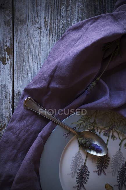 Flores violetas em torno de pratos e tecidos — Fotografia de Stock