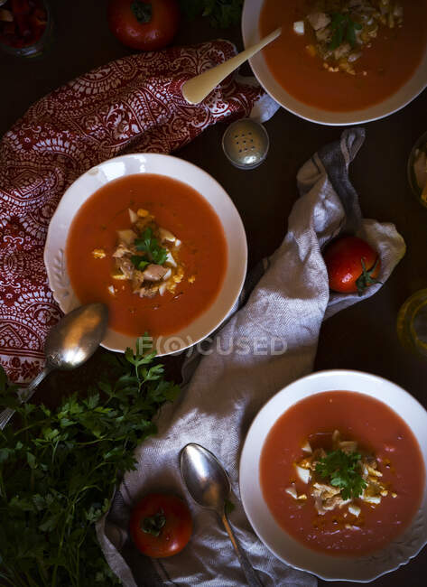 De acima mencionadas tigelas de sopa de tomate deliciosa com salsa colocada perto de guardanapos na mesa — Fotografia de Stock