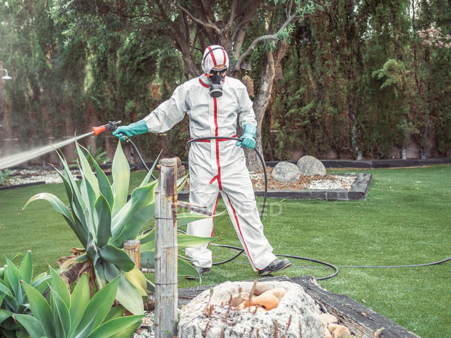 Fumigador en sustancia pulverizadora uniforme blanca en el jardín - foto de stock