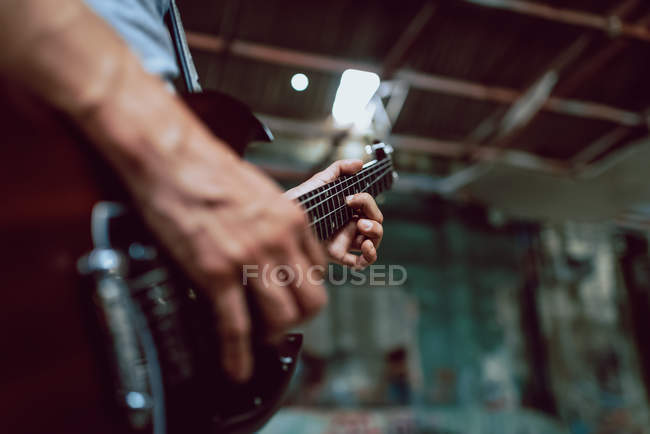 Cuerdas de sujeción del hombre al cuello de guitarra - foto de stock
