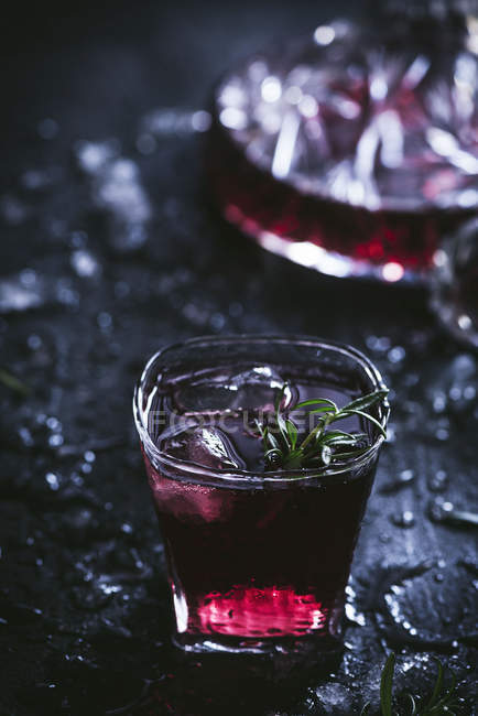 Caraffa e bicchieri di cristallo con ghiaccio ripieni di vino rosso sul tavolo nero — Foto stock