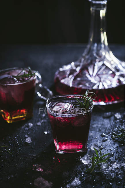 Графины и бокалы со льдом с красным вином на черном столе — стоковое фото