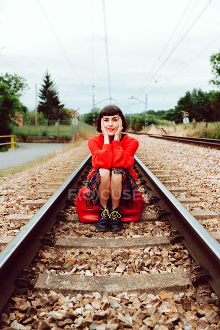 Mujer sentada en traviesas en medio del ferrocarril - foto de stock