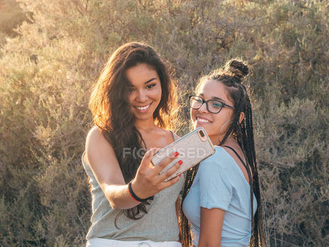 Smiling trendy young women taking selfie at countryside — Stock Photo