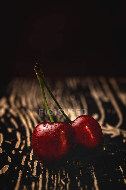Tasty appetizing ripe cherries on dark wooden table — Stock Photo