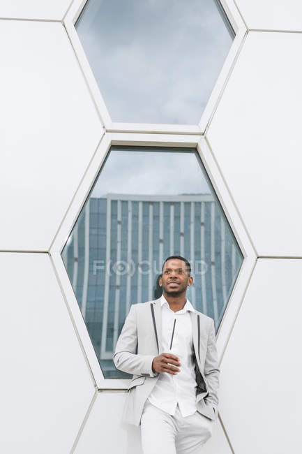Чорний чоловік з кавою стоїть в центрі міста — стокове фото