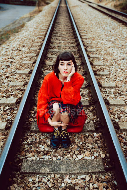 Mulher sentada em dormentes no meio da ferrovia — Fotografia de Stock