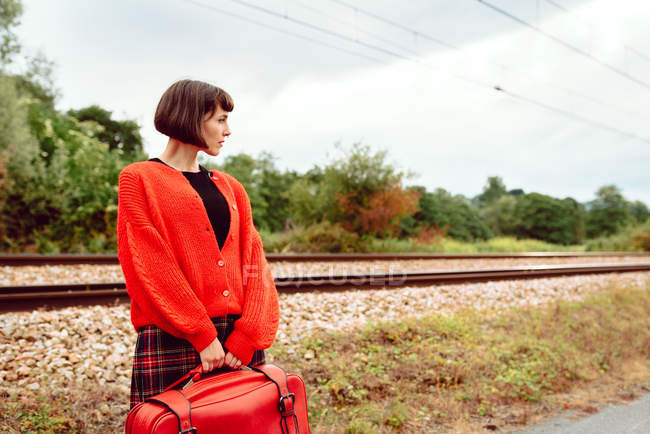 Jovem mulher de pé na estação de trem no campo — Fotografia de Stock