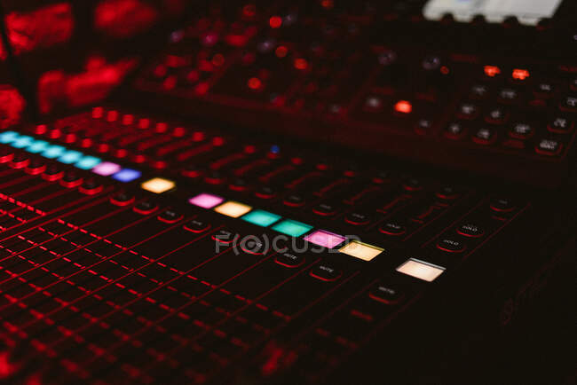From above bright vivid DJ music console with glowing colorful buttons in dark club during play — Stock Photo