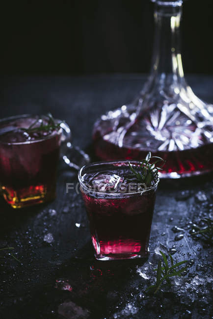 Vidrio de caramelo y cristal con hielo lleno de vino tinto en la mesa negra. - foto de stock