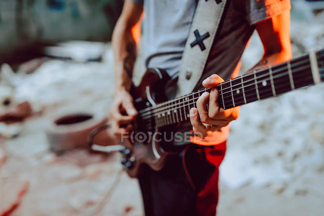 Man clamping strings on guitar neck — Stock Photo