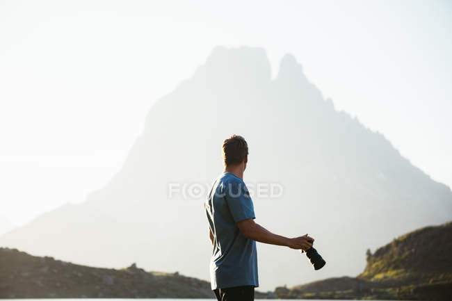 Чоловік фотографує гірський пейзаж — стокове фото