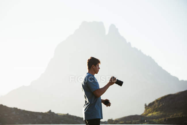 Hombre tomando fotos de paisaje de montaña - foto de stock