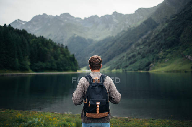 Человек наслаждается горным пейзажем и озером — стоковое фото