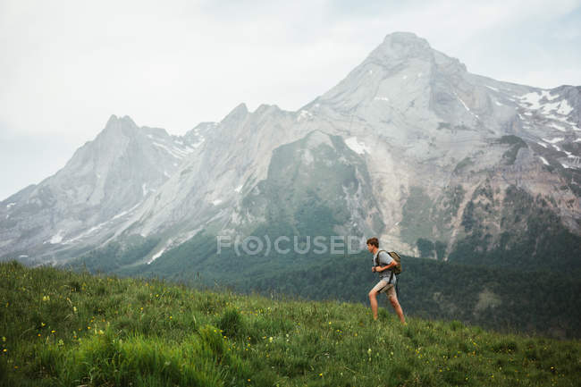 Homme avec sac à dos randonnée dans les Pyrénées montagnes — Photo de stock