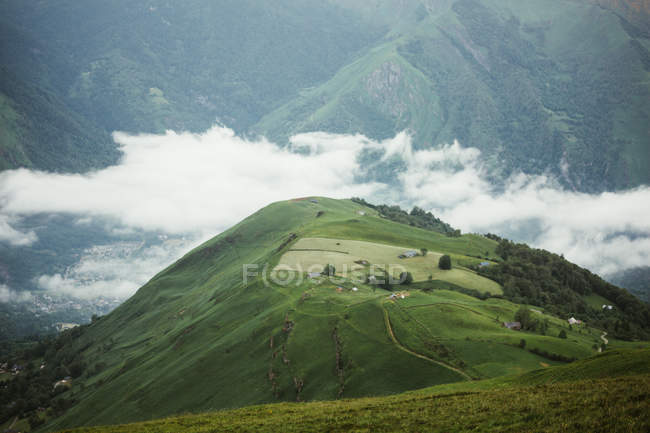 De cima vista de pequeno povoado cercado por névoa matinal nas montanhas dos Pirenéus — Fotografia de Stock