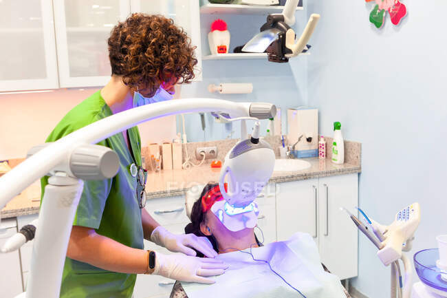 Пациент лежит в стоматологическом кресле во время рентгеновской процедуры — стоковое фото