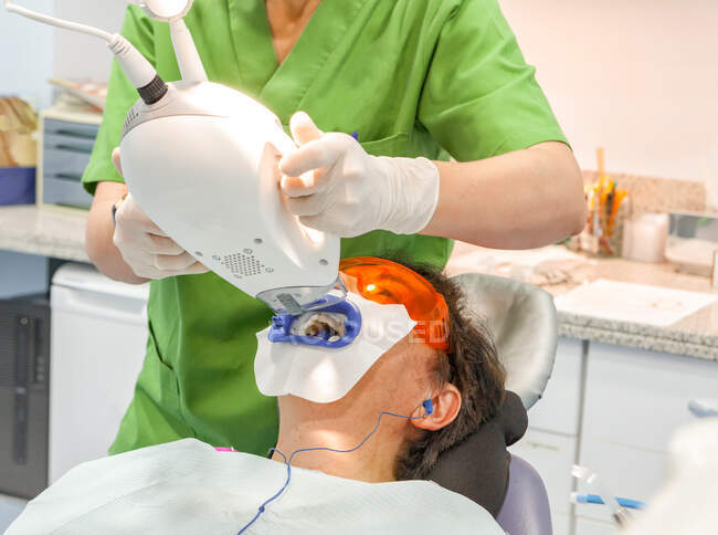 Dentista tomando rayos X digitales al paciente en silla - foto de stock