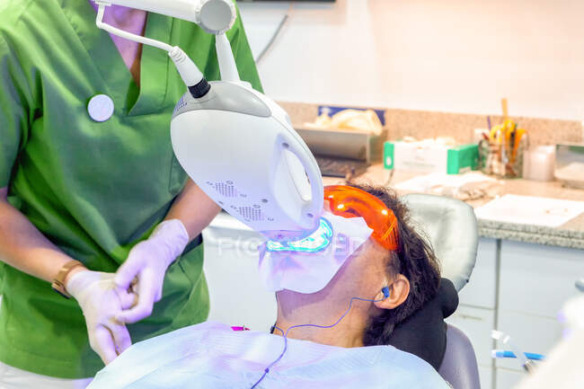 Paciente acostado en silla dental durante el procedimiento de rayos X - foto de stock