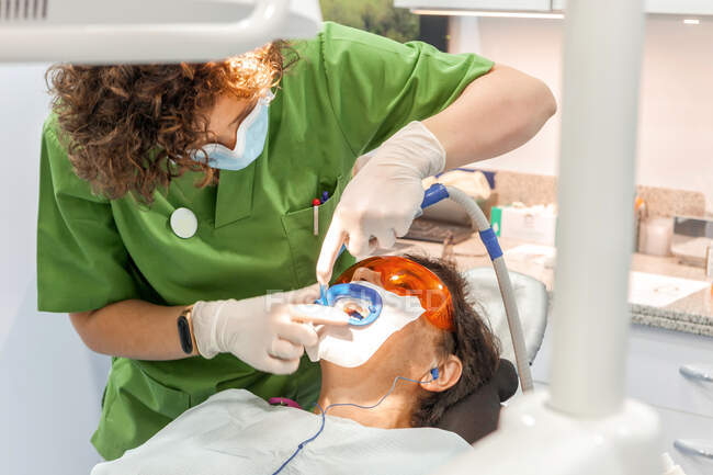 Dentist making teeth filling in mouth of patient — Stock Photo