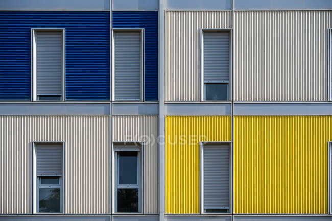 Extérieur de la maison urbaine colorée contemporaine avec de longues fenêtres étroites à moitié ouvertes — Photo de stock