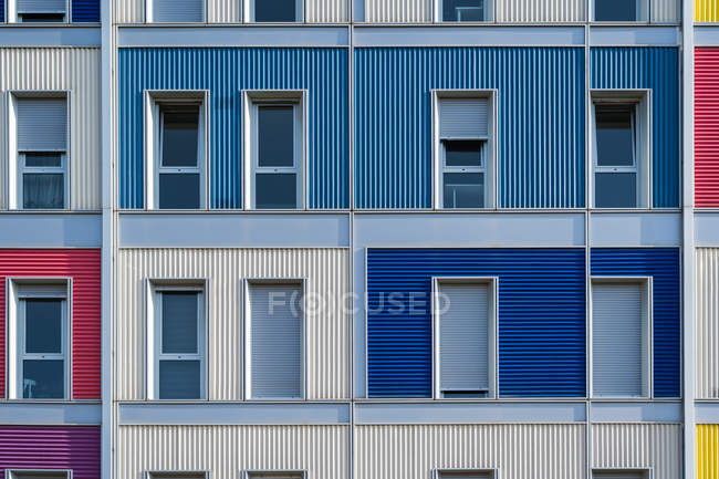 Exterior de la casa urbana colorida contemporánea con largas ventanas estrechas medio abiertas - foto de stock