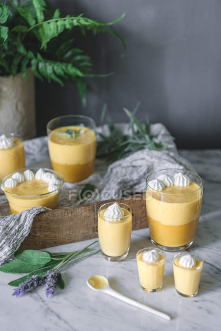 Tasty aromatic mango mousse in glasses on white marble tabletop — Stock Photo