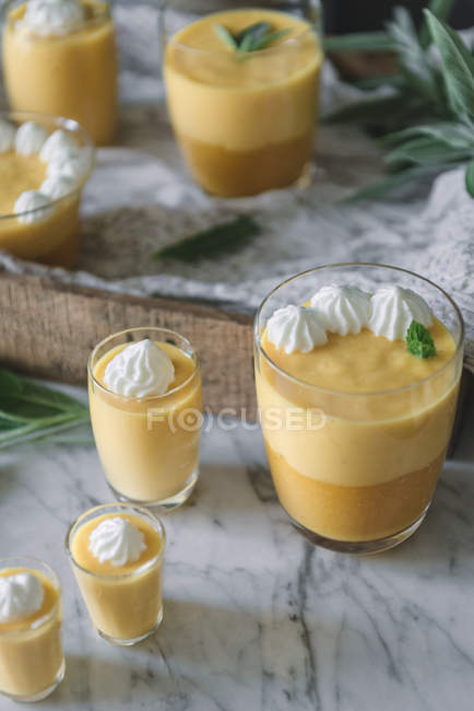 Крупним планом смачний ароматичний мус манго в окулярах на стільниці з білого мармуру — стокове фото