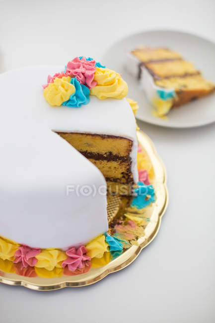 Вкусный день рождения сладкий торт с ломтиком на тарелке на белой поверхности — стоковое фото