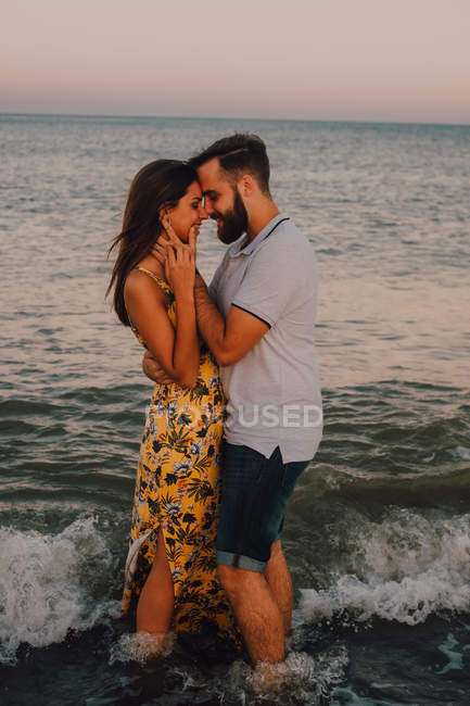 Homem amoroso abraçando mulher encantadora suavemente à beira-mar — Fotografia de Stock