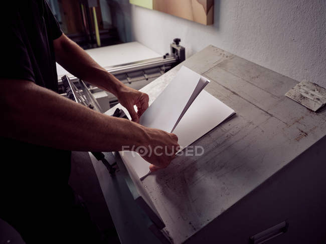 Руки безликих робітників у процесі книгодробництва з використанням професійного обладнання в друкарні — стокове фото