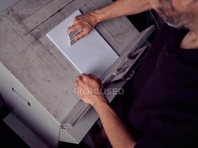 Безликий працівник, що працює з папером у друкарні — стокове фото