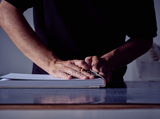 Hands of craftsman making book in workshop — Stock Photo