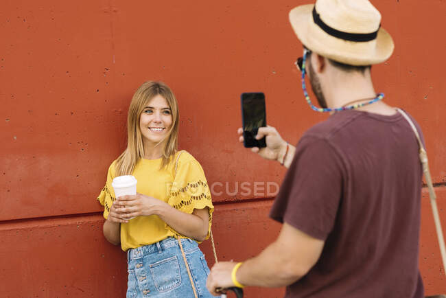 Молода жінка позує з кавою для чоловіка — стокове фото